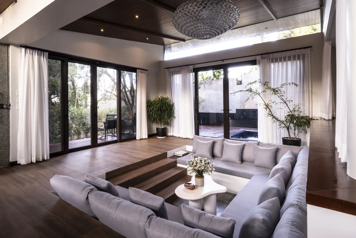 Ezra Viniti spacious living area with sunken sofa and garden views
